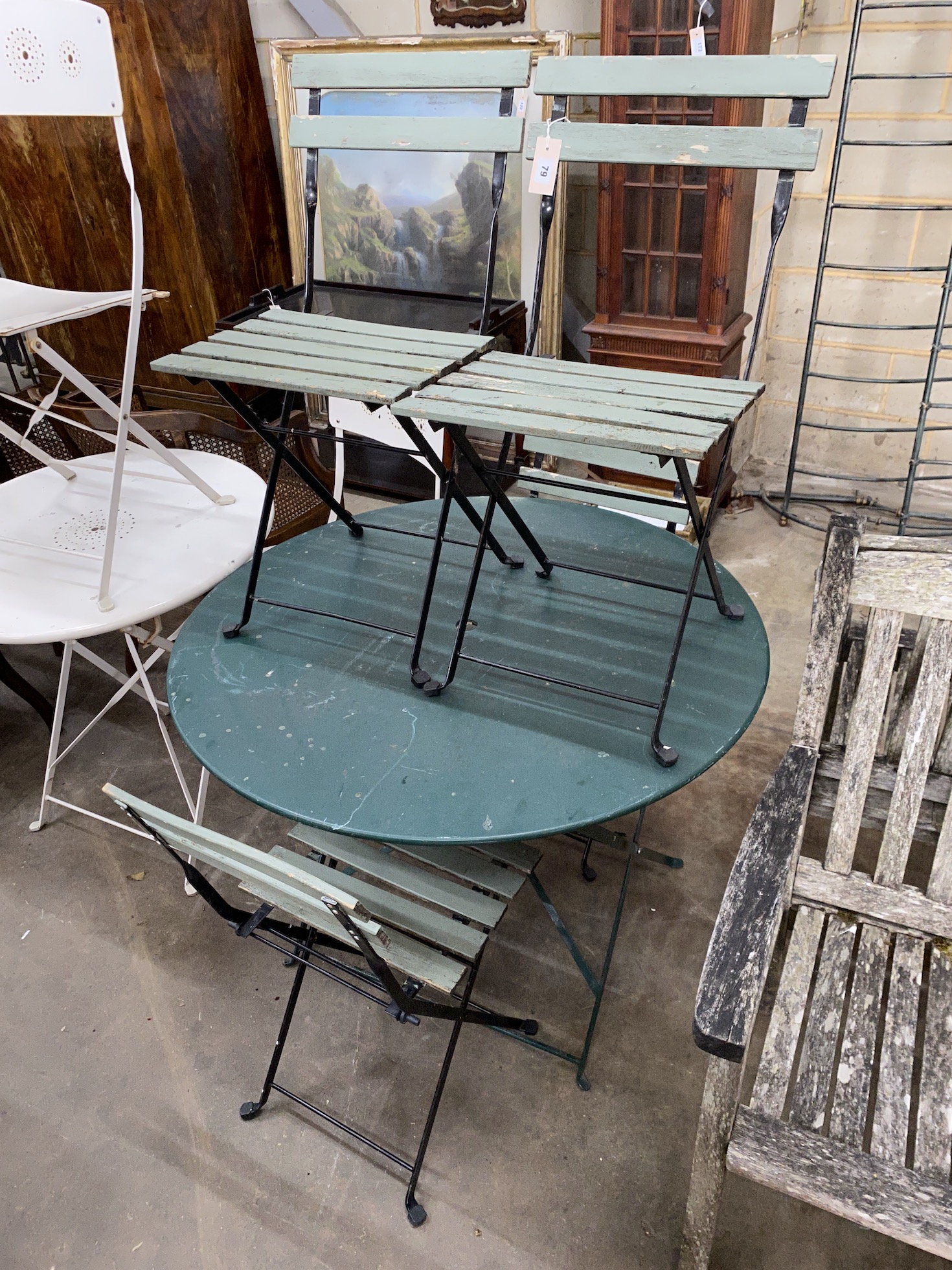 A circular metal folding garden table, diameter 96cm, height 72cm together with four slatted folding garden chairs